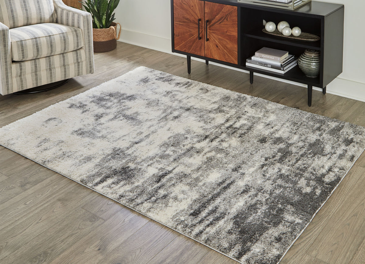 Gray abstract area rug under a chair and sideboard in a living room